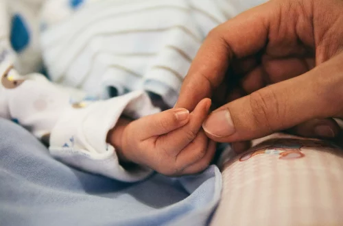 Italian citizenship with children: Photo of a parent holding their baby hands