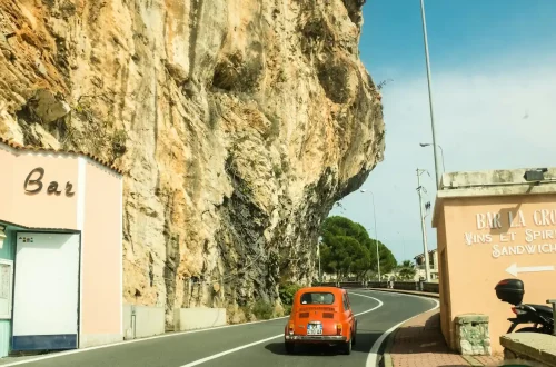 Exploring the Italian and American cultural differences: Photo of a classical Italian car in a mountain road