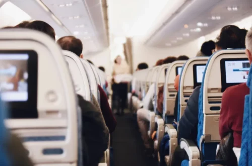 Photo of the interior of a plane with the passengers on a travel to Italy