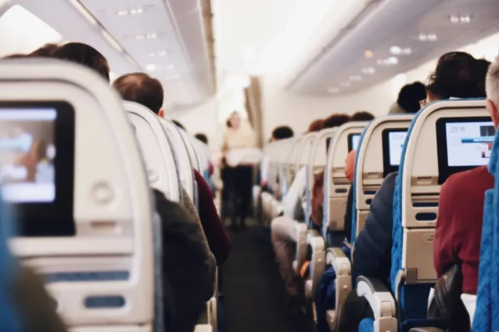 Photo of the interior of a plane with the passengers on a travel to Italy