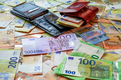 What is a good salary in Italy: Photo of wallets on top of piles of Euro notes