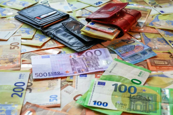 What is a good salary in Italy: Photo of wallets on top of piles of Euro notes