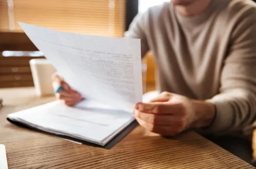 Photo of a person looking on a paper where to apply for italian citizenship