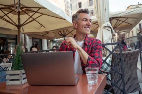 working-in-italy-as-american-citizen Working in Italy as an American citizen: Photo of a man remote working in a street cafe in Rome